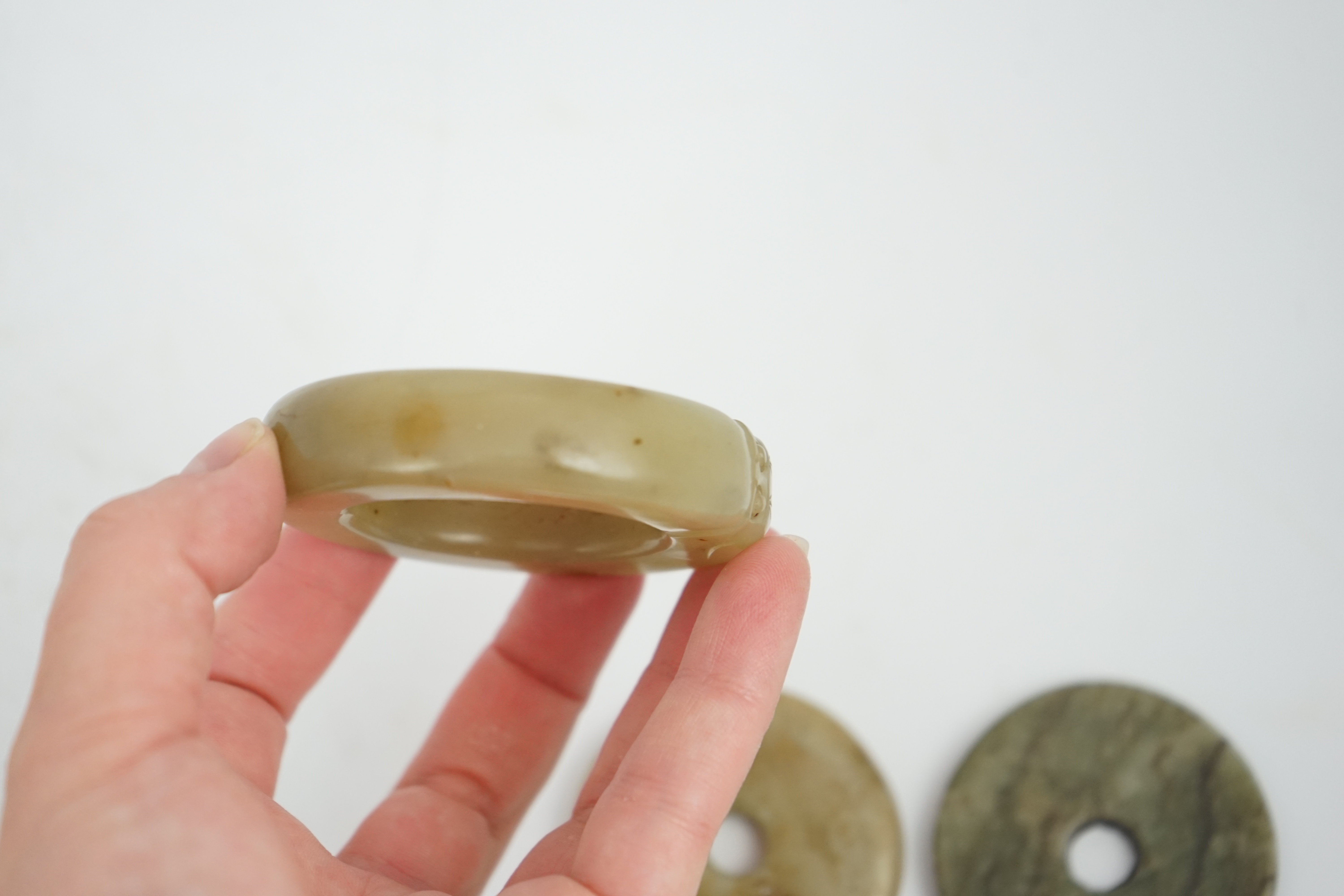 Two Chinese soapstone bi discs, and a jade ring, 18th century or earlier, largest 6.5cm in diameter. Condition - good